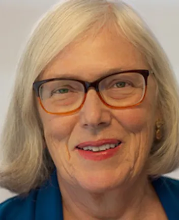 Older woman with gray hair wearing glasses and blue jacket