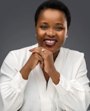 Smiling woman in white blouse with hands clasped