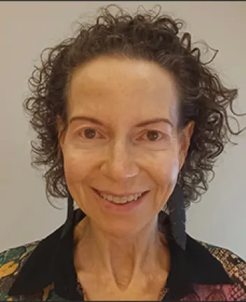 Smiling woman with curly hair and earrings