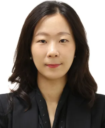 Professional headshot of woman with dark hair, black blazer