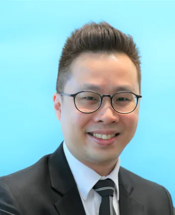 Smiling professional man wearing glasses and suit.